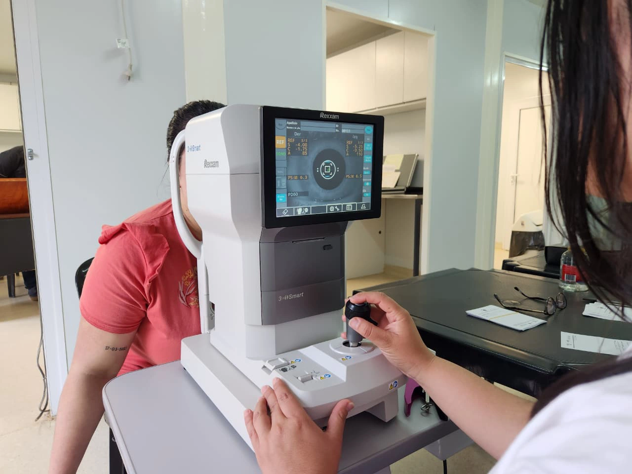 Oftalmóloga revisa los ojos de una vecina mediante un autorefractómetro. Mirar Mejor en Bernardo De Irigoyen.