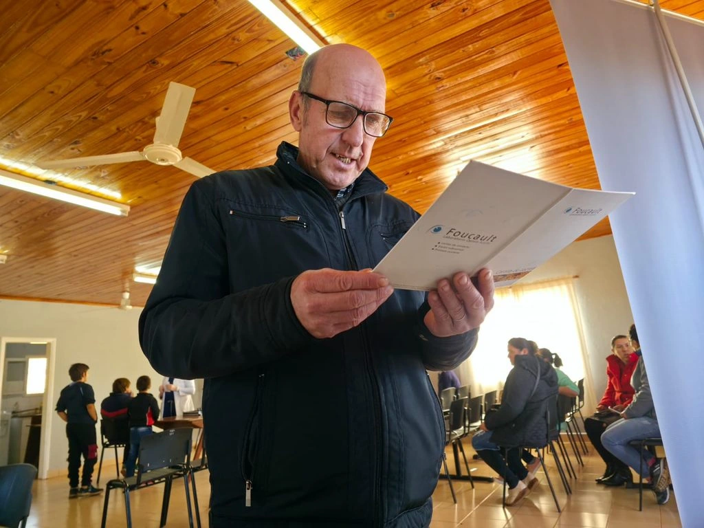 Vecino de General Alvear lee un texto con sus nuevos anteojos de Mirar Mejor.