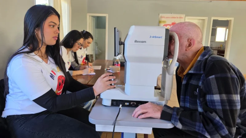 Oftalmóloga revisa los ojos de un vecino mayor mediante un autorefractómetro. Mirar Mejor en General Alvear.