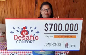 Adela sonríe con su cheque. Con el dinero del premio de Desafío Confort comprará electrodomésticos que necesita.