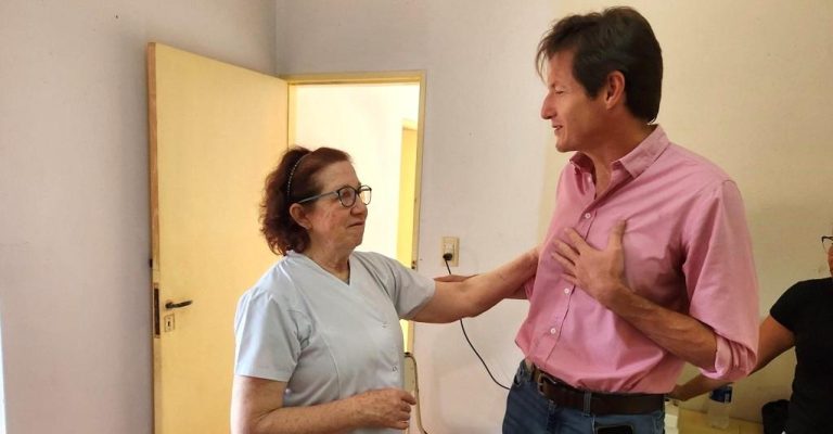 Héctor Decut y una docente charlan animadamente durante el operativo Estamos con vos.