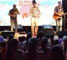 Poca Sopa y Suena Sanfona cantan en el escenario frente al público infantil.