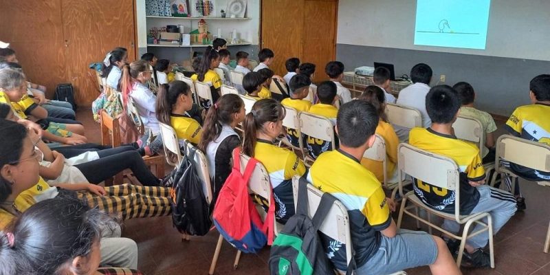 Alumnos y docentes de Escuela 732 miran video durante la charla de prevención de adicciones.