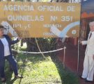 Kusy Ceslao y su esposo frente al cartel de su agencia.