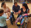 Decut charla con dos mamás con sus hijos en el patio de la escuela